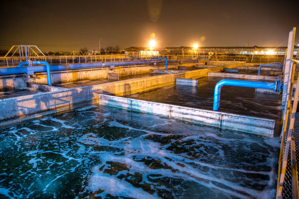 Modern wastewater treatment plant of chemical factory at night. Water purification tanks.